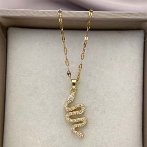 Macro detail of a 18K gold plated snake pendant necklace with shimmering zircon stones