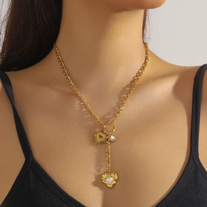 Détail d'un collier en Y plaqué or avec pendentifs soleil et cœur sur un mannequin