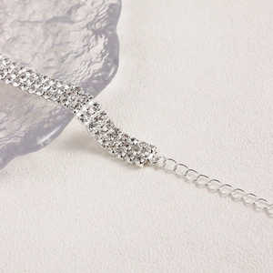 Macro detail of silver choker with three rows of sparkling rhinestones and adjustable chain