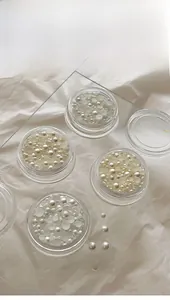 Flatback white pearl nail art accessories in assorted sizes stored in clear containers