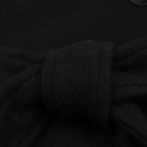 Detail of black wool coat featuring a textured weave and a tied waist belt knot
