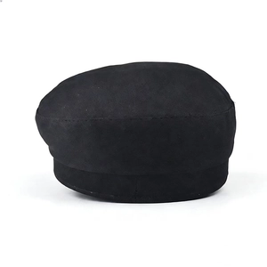 Détail de la casquette gavroche noire avec texture en daim doux et chaîne métallique