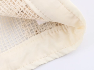Macro shot of fine beige mesh fabric texture with high-quality edge stitching details