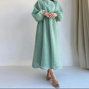 Detail of mint green jacquard mesh dress featuring puff sleeves and textured fabric
