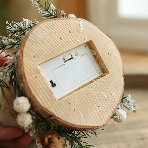 Bottom detail of a wooden Christmas tree house with LED battery compartment and pine decor