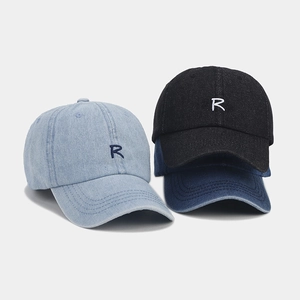Detailed shot of three denim baseball caps with R embroidery in light blue, dark blue and black