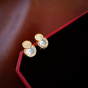 Detailed shot of gold-plated geometric zircon stud earring on luxury red jewelry box