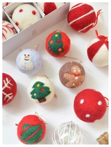 Detailed view of handmade wool felt Christmas ornaments with gingerbread and snowman patterns