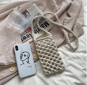 Detail of cream macrame woven phone bag showing intricate handmade diamond mesh pattern