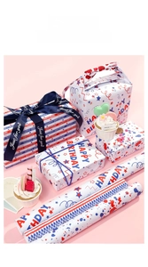 Detail showing Happy Birthday gift wrapping paper with colorful stars and pink ribbons