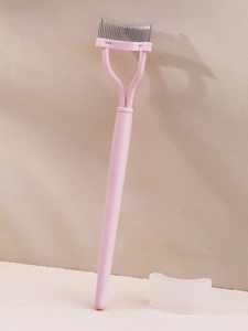 Macro detail of pink lash separator with fine stainless steel teeth and protective cap