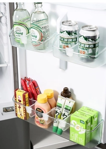 Close-up of a clear plastic organizer box used for sorting sodas and sauces in a fridge