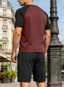 Outdoor view of men's two-piece set featuring burgundy raglan t-shirt and black shorts