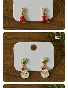 Detail of Christmas earrings featuring Santa Claus and red ice skates on wood background