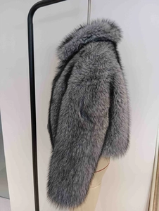 Détail du manteau en fausse fourrure grise et noire avec texture épaisse et capuche