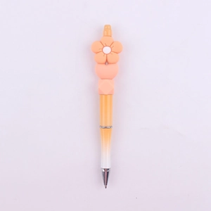 Close-up of a creative DIY beaded pen with an orange silicone daisy flower on top