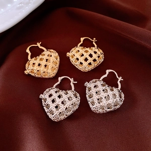 Detail showing hollow heart earrings with woven mesh texture in gold and silver
