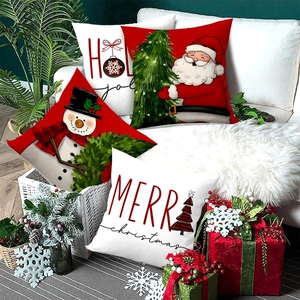Set of 4 Christmas pillow covers with Santa and snowman prints on a white sofa decor