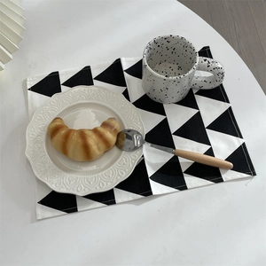 Macro detail of geometric black and white triangle printed placemat on a white table