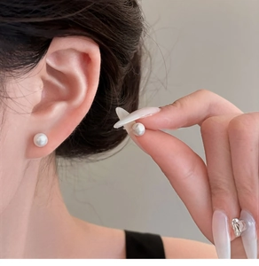 Close-up of elegant 6-8mm freshwater pearl stud earrings worn on a model's ear