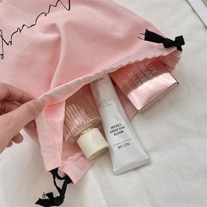 Pink linen drawstring bag showing interior storage for perfume and cosmetics
