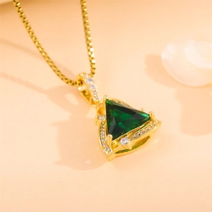 Golden triangle necklace with green crystal and zircon stones on orange background