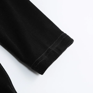 Detailed close-up of premium black velvet sleeves on a luxury mini dress with soft texture