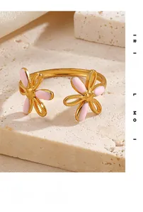 Dettaglio anello aperto dorato con due fiori in smalto rosa su base in pietra