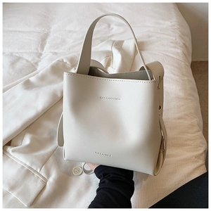 Detailed macro shot of the MACGHEE cream white leather bucket bag showing minimalist texture