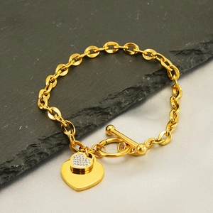 Detail of gold double heart charm bracelet with OT clasp and sparkling zircon stones