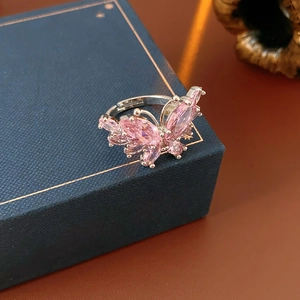 Vue détaillée d'une bague papillon avec zircon rose sur un coffret à bijoux élégant