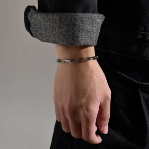 Close-up of minimalist silver paperclip chain bracelet worn on male wrist
