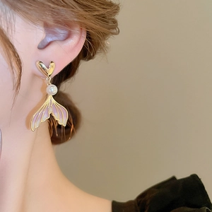 Detail of mermaid tail pearl earring featuring pink gradient enamel and gold heart stud