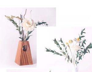 Detail of wooden aromatherapy diffuser set with handmade sola flowers and eucalyptus leaves