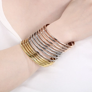 Detail of 3.6mm stacked stainless steel bangles in gold, silver, and rose gold finish