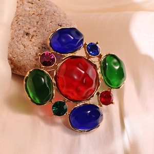 Macro shot of vintage style colorful brooch with rhinestones on stone background