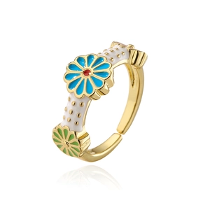 Detail view of adjustable gold plated floral ring with blue and green daisy patterns