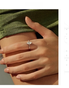 Detail of marquise-cut moissanite ring with diamond accents on a rose gold band