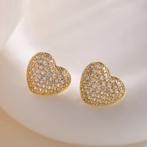 18K gold-plated heart stud earrings with cubic zirconia on white silk background