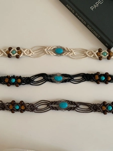 Detailed view of bohemian waist belts featuring wooden beads and turquoise oval stones