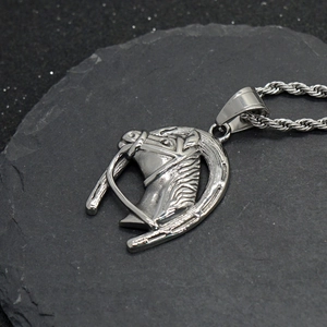 Vue détaillée du pendentif tête de cheval et fer à cheval en acier argenté sur chaîne torsadée