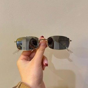 Macro detail of retro small square silver metal frame sunglasses with dark lenses
