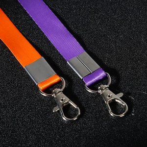 Orangefarbene und violette Nylon-Lanyards mit Metallkarabinern auf schwarzem Grund