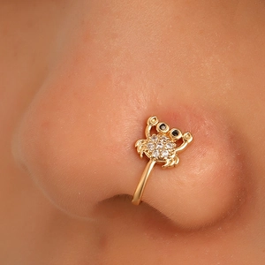 Macro side view of crab-shaped non-piercing gold nose cuff with zircon inlay on model