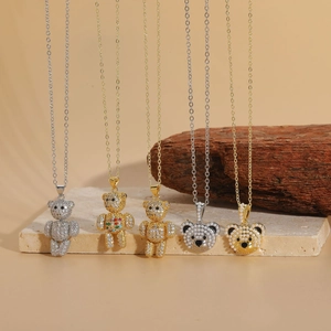 Detailed view of luxury bear pendants with pavé zircons and pearls in gold and silver