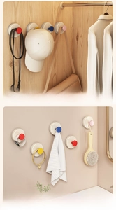 Multi-colored vacuum suction hooks organizing belts and bags in a minimalist closet
