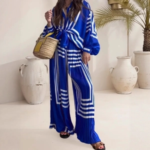 Detailed view of royal blue and white striped pleated wide-leg pants and matching shirt