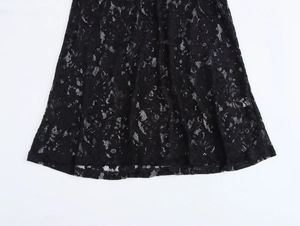 Close-up of elegant black floral lace pattern and curved hemline on a fitted dress