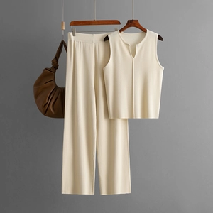 Detail of cream sleeveless knit top and wide-leg pants set on a wooden hanger
