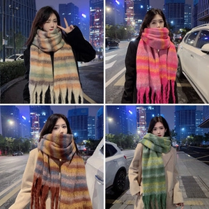 Detailed view of soft mohair plaid scarves in four colors with fringe on city streets